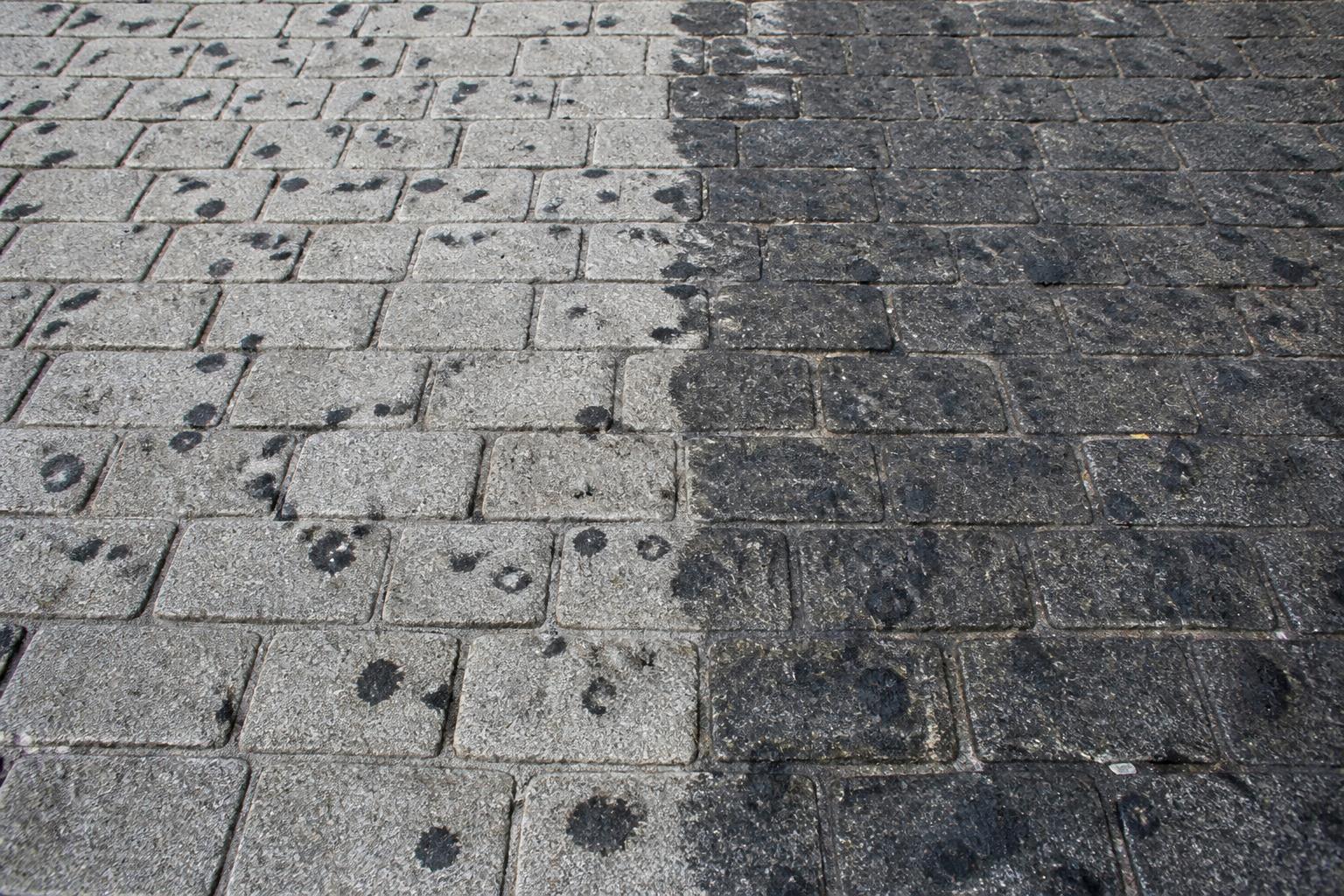 Kaugummiflecken auf Pflasterfläche – halb gereinigt, halb verschmutzt